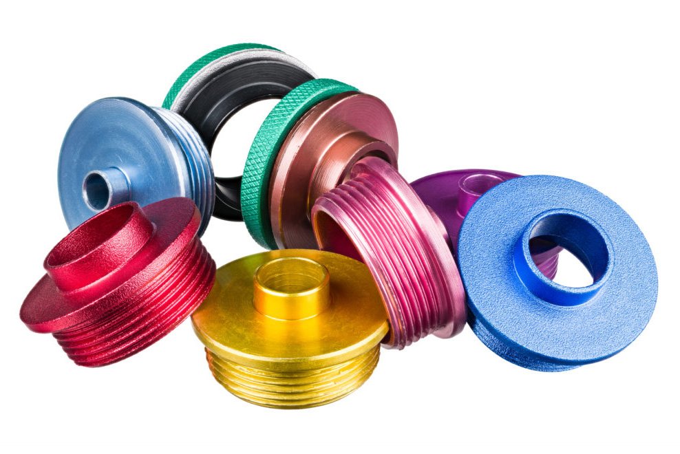 Closeup of colorful metal copy rings pile of anodized aluminum alloy. Wood shaping and milling tools accessory. Woodworking equipment